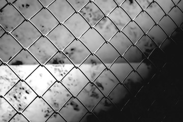 metal chain link fence pattern soft focus above concrete wall background