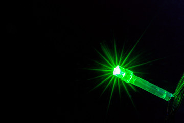 Obraz premium Green color light bulb on the dark background.