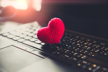 Red heart on computer laptop keyboard for love chat online dating - obrazy, fototapety, plakaty