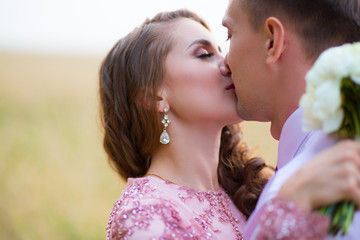 Young couple kissing in summer field