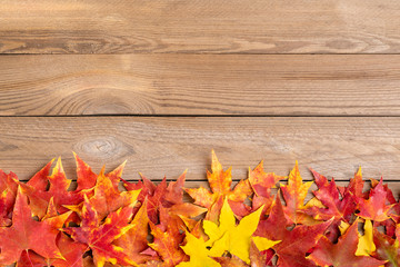 Obraz premium Background texture with old wooden table and yellow autumnal fallen maple leaves Top view Flat lay copy space Place for text Hello autumn, september, october, november, nature concept Rustic style 