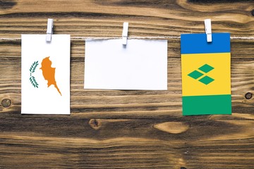 Hanging flags of Cyprus and Saint Vincent And The Grenadines attached to rope with clothes pins...