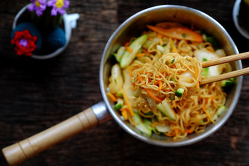 human hand mix  instant noodles with vegetables for quick vegan breakfast