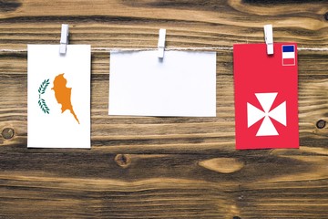 Hanging flags of Cyprus and Wallis And Futuna attached to rope with clothes pins with copy space on...