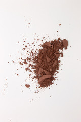 This is a photograph of a deep Brown Powder Eyeshadow isolated on a White Background