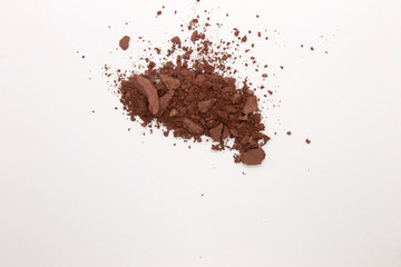 This is a photograph of a deep Brown Powder Eyeshadow isolated on a White Background