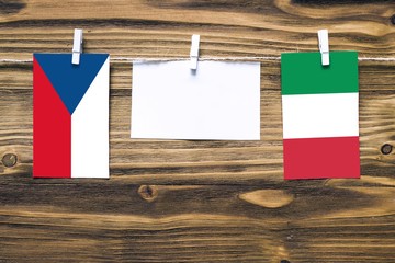 Hanging flags of Czech Republic and Italy attached to rope with clothes pins with copy space on...