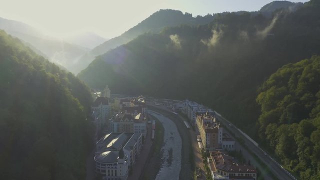 Aerial view fly above rosa khutor valley in mountain. Sunny summer morning