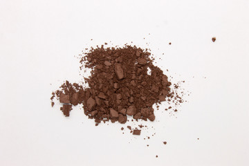 This is a photograph of a Dark Brown Powder Eyeshadow isolated on a White Background