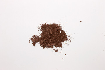 This is a photograph of a Dark Brown Powder Eyeshadow isolated on a White Background