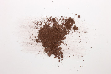 This is a photograph of a Dark Brown Powder Eyeshadow isolated on a White Background