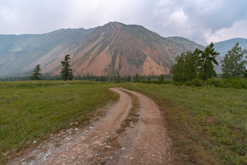 Fototapeta na wymiar field road to red mountain