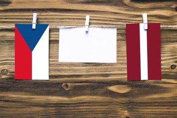 Hanging flags of Czech Republic and Latvia attached to rope with clothes pins with copy space on...