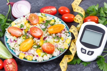 Glucose meter for analyzing sugar level and salad with bulgur groats and vegetables. Diabetes,...