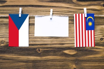 Hanging flags of Czech Republic and Malaysia attached to rope with clothes pins with copy space on...