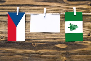 Hanging flags of Czech Republic and Norfolk Island attached to rope with clothes pins with copy...