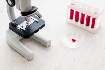 Blood testing laboratory. Samples viewing under microscope near tubes on white background top view space for text