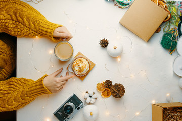 Coffee and cake with cream on the table. Female drinking coffee and eating cake.