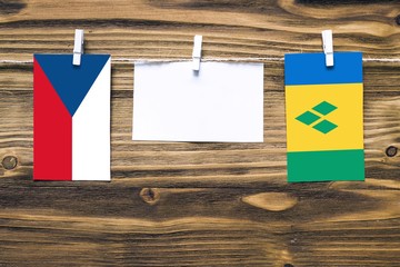 Hanging flags of Czech Republic and Saint Vincent And The Grenadines attached to rope with clothes...