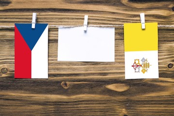 Hanging flags of Czech Republic and Vatican City attached to rope with clothes pins with copy space...
