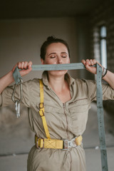 Girl in overalls closes her mouth with harness
