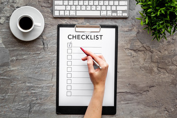 Hand fill checklist on grey office background top view
