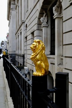 Golden lion figure on railings in London