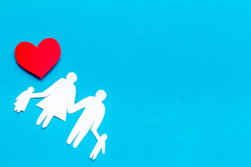 Happy family concept. Heart icon near mom, dad and childrens cutout on blue background top view space for text