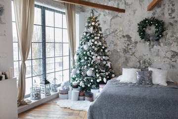 Christmas, New Year silver-grey interior with texture grey wall background, decorated fir tree with garlands, white and silver balls, Christmas gifts, lanterns and large window