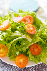 Tomato, and lettuce salad on table.