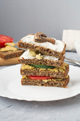 Vegetarian sandwich with tomato, mushrooms, cucumber, cauliflower and hummus.