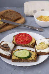 Vegetarian sandwich with tomato, mushrooms, cucumber, cauliflower and hummus.