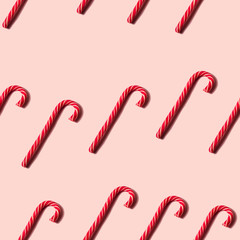 Seamless Christmas texture made of candy cane and shadow on pink background. Minimal design for you