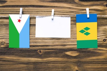 Hanging flags of Djibouti and Saint Vincent And The Grenadines attached to rope with clothes pins...