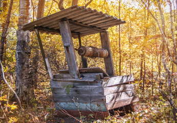 Abandoned water well skewed and unused for a long time in the forest © Aleksei