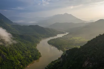 Fototapeten Aerial view of mountains and river Nong Khiaw. North Laos. Southeast Asia. Photo made by drone from above. Bird eye view. © Curioso.Photography