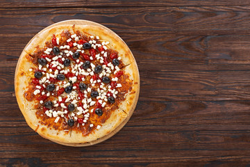 Pizza with cheese. Close-up, overhead view, wooden table