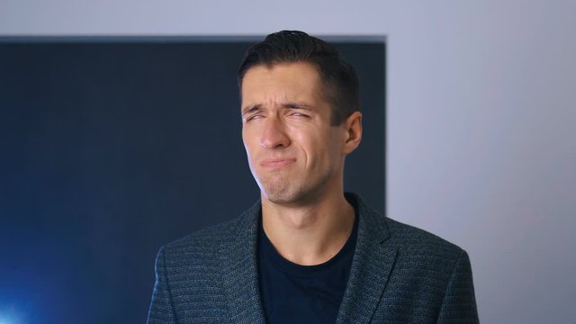 Portrait of attractive man making facepalming pose with hand. Showing an expression of dismay, exasperation, embarrassment. Businessman is disappointed and covers his face with his hand.