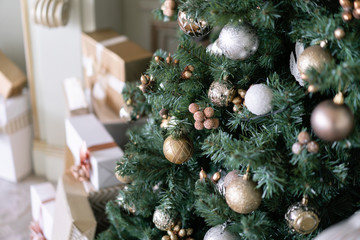 Close-up branches of Christmas tree with ornaments. Christmas balls, ribbon bow, snowflakes, pine cones and lights.