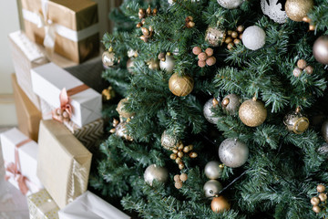 Close-up branches of Christmas tree with ornaments. Christmas balls, ribbon bow, snowflakes, pine cones and lights.