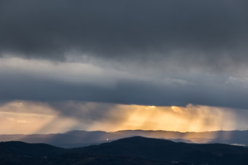 Sunrays coming over mountains in Umbria (Italy) with beautiful golden hours colors.