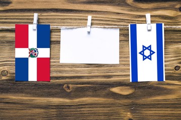 Hanging flags of Dominican Republic and Israel attached to rope with clothes pins with copy space...