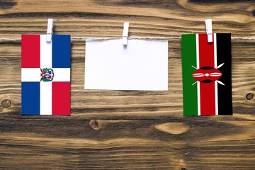 Hanging flags of Dominican Republic and Kenya attached to rope with clothes pins with copy space on...