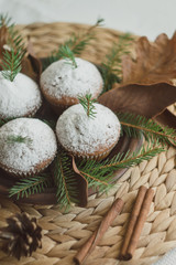 Christmas cupcakes on a straw wicker stand. Cupcakes decorated with fir branches and cones.