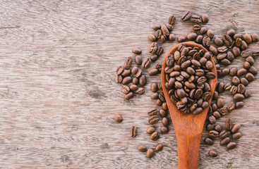 Coffee Beans in wooden spoon on old wood background