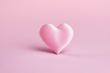Pink silk heart on a pink background. The concept of minimalism. Place for text. Pastel colors .