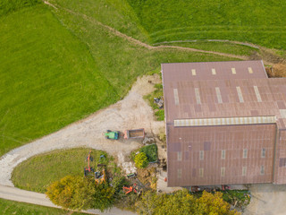 Aerial view of farming tractor in front of farmhouse in Switzerland.