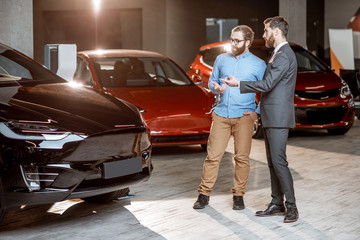 Client with a salesman at the showroom with electric cars