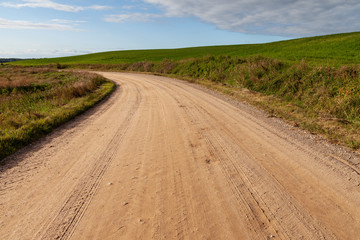 Fototapeta na wymiar Gravel road in countryside landscape.