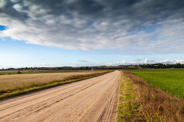 Fototapeta na wymiar Gravel road in countryside landscape.